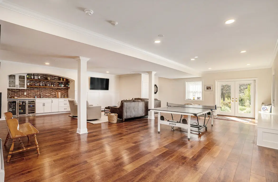 Bright finished basement with brick-arch wet bar and game area — Harlan Custom Contracting project