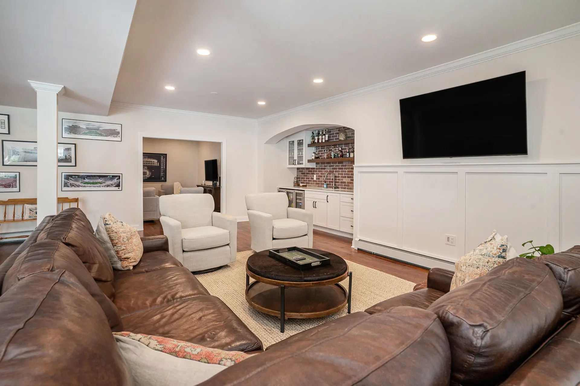 Basement family room with board-and-batten wainscoting and brick-accent bar — Harlan Custom Contracting project