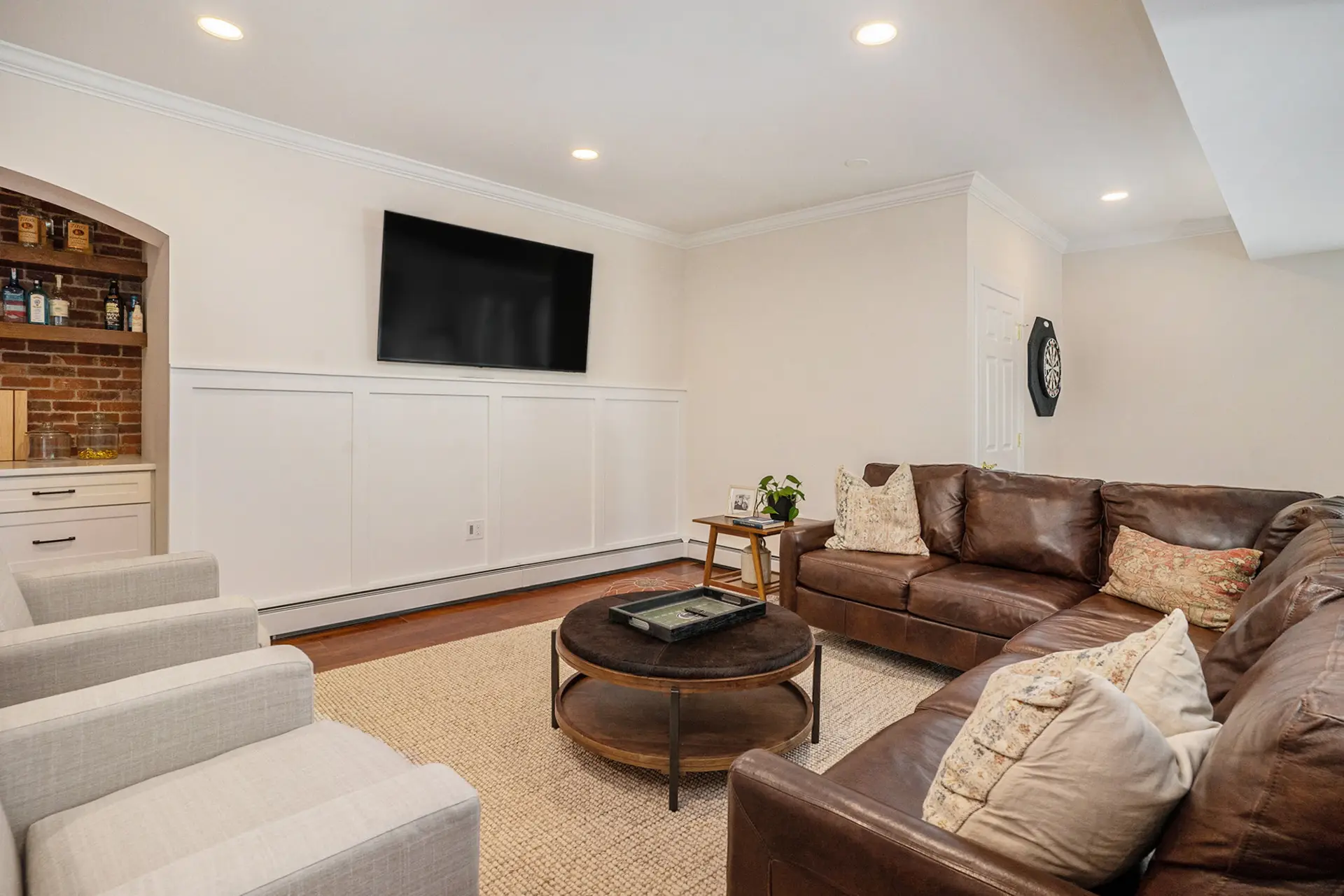Finished basement lounge with leather sectional and built-in bar — Harlan Custom Contracting project