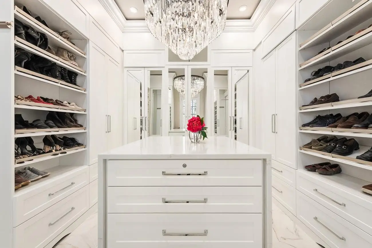 Custom walk-in closet with island, shoe shelving, and chandelier — Harlan Custom Contracting project