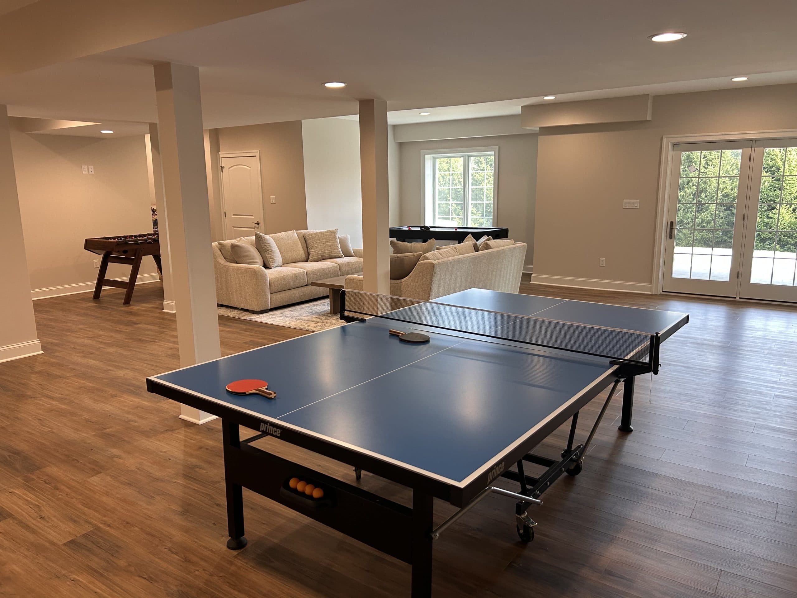 Walk-out basement rec room with table tennis and pool table — Harlan Custom Contracting project