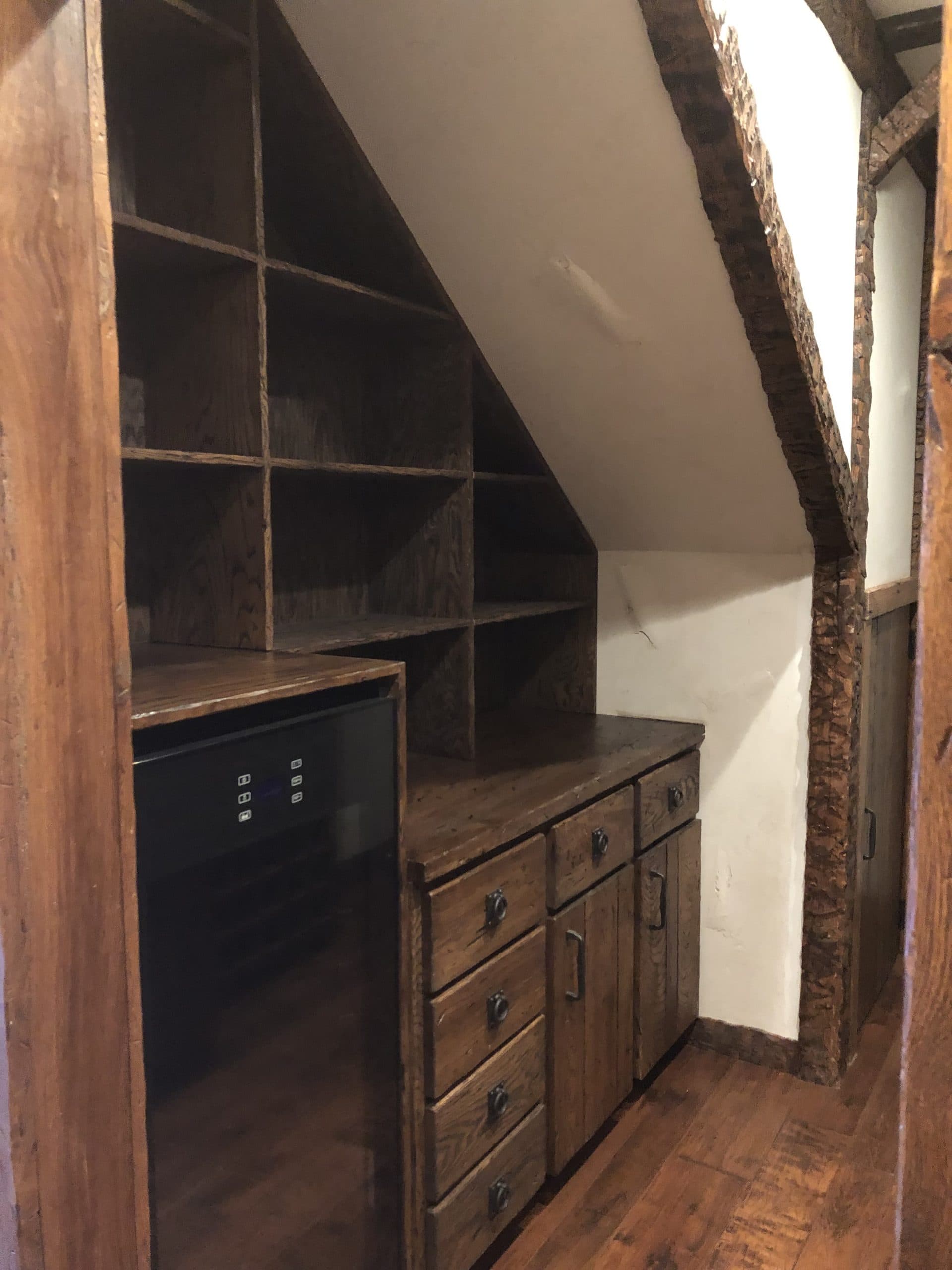 Custom under-stairs oak cabinetry and beverage center built by Harlan Custom Contracting