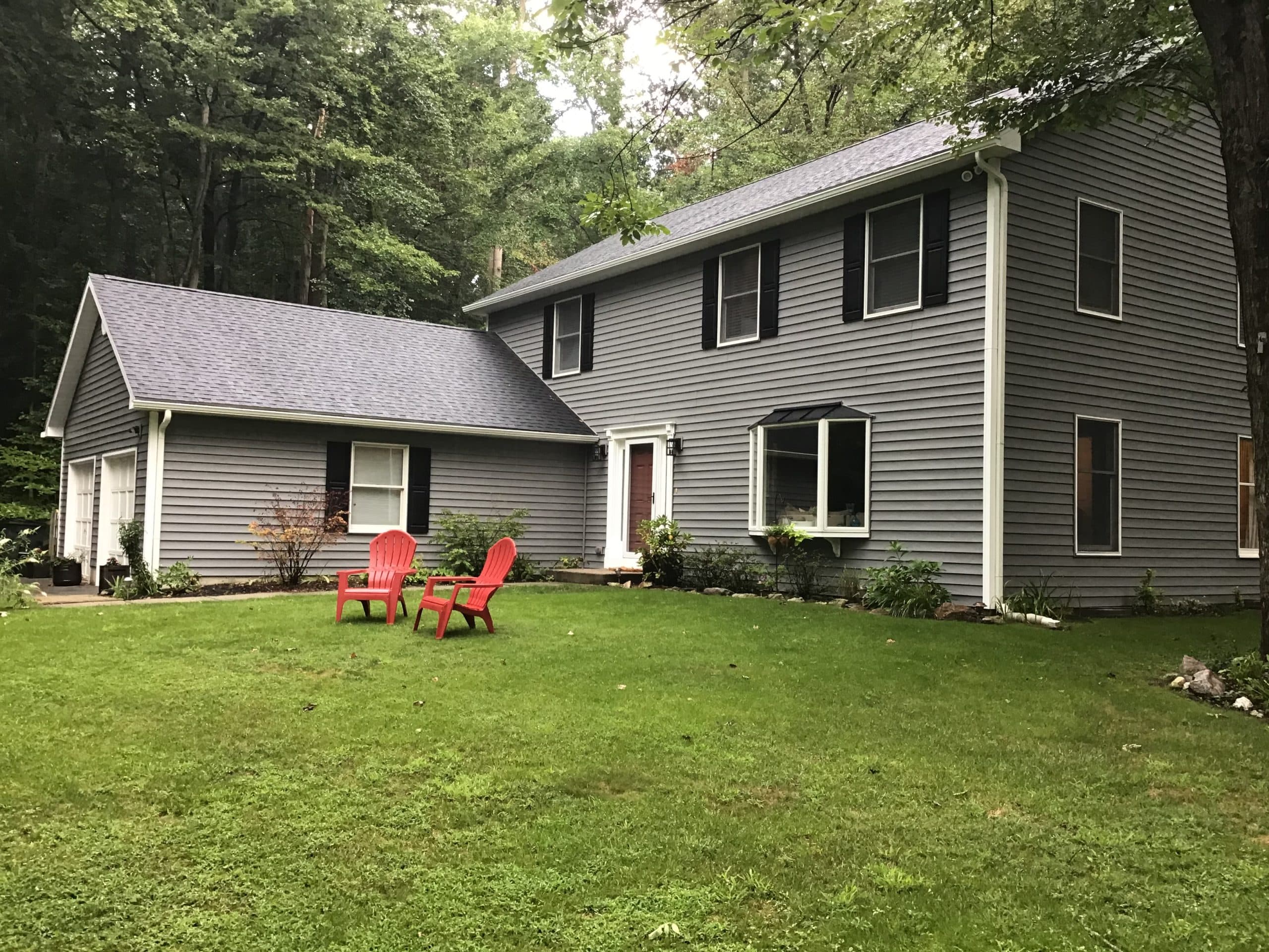 Home re-clad with new gray siding after stucco removal by Harlan Custom Contracting