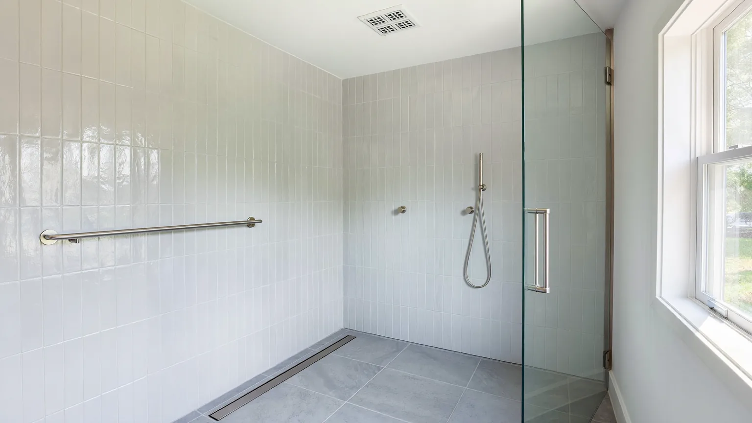 Curbless walk-in shower with grab bar and ceiling exhaust fan